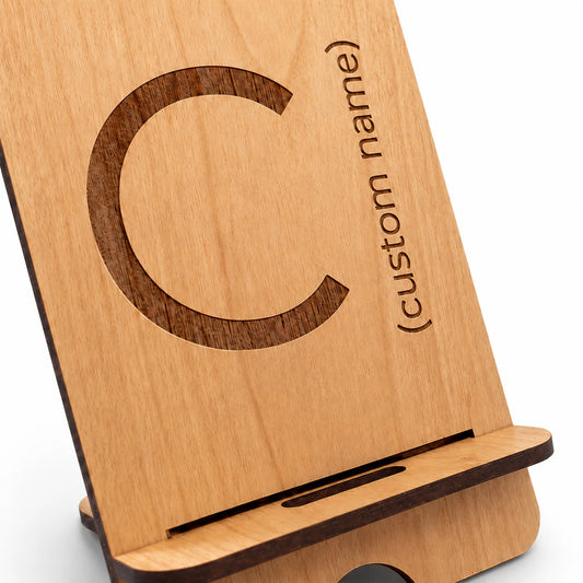 Custom wooden phone stand with engraved letter and text on light wood