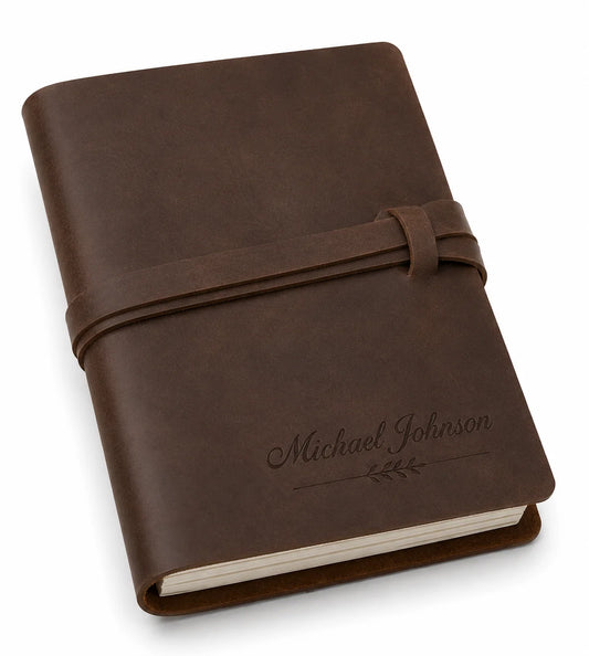 Brown leather-bound journal with embossed name and tied strap on cover